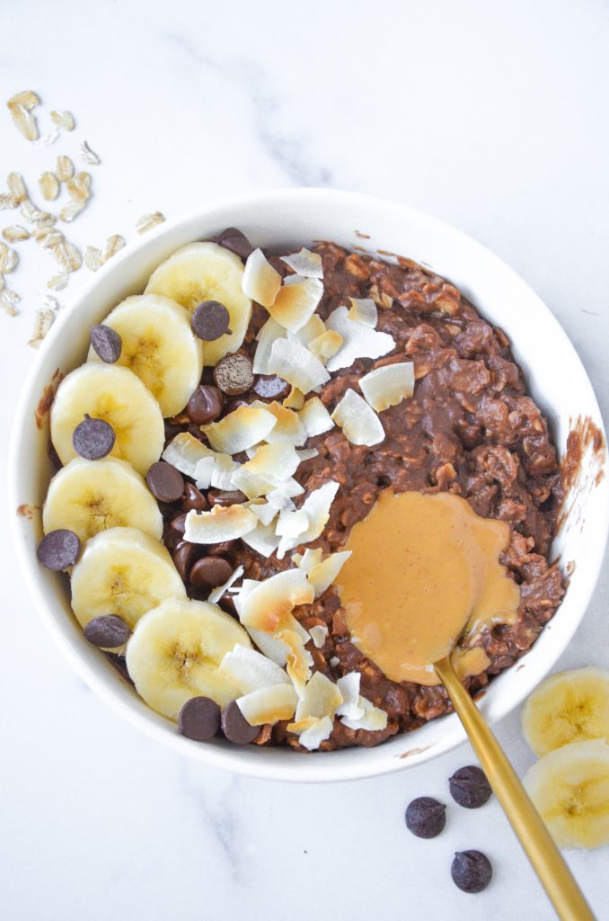 Chocolate protein oatmeal topped with banana in a bowl. 