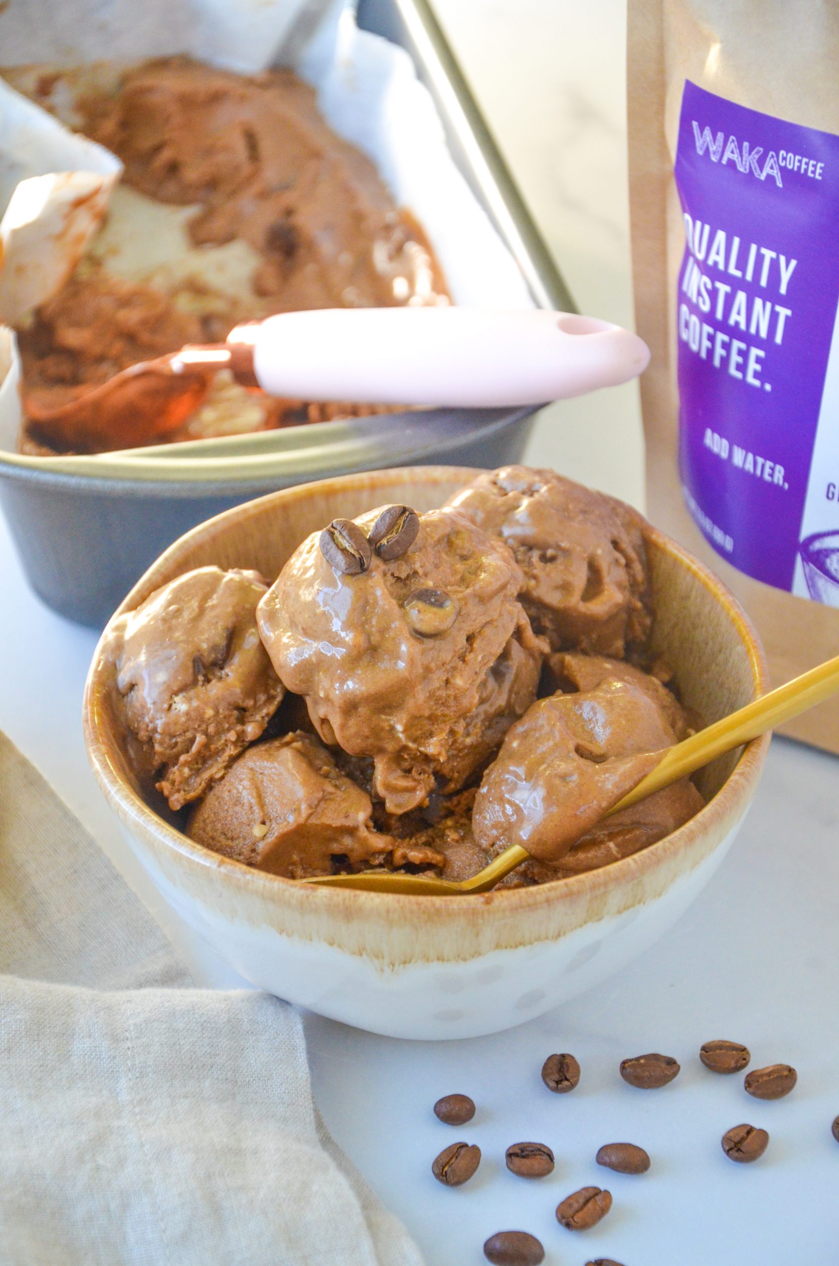 A bowl of coffee ice cream with a spoon inside.