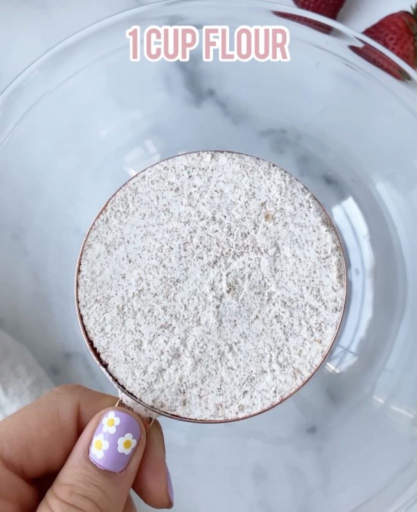 flour in a measuring cup over a bowl