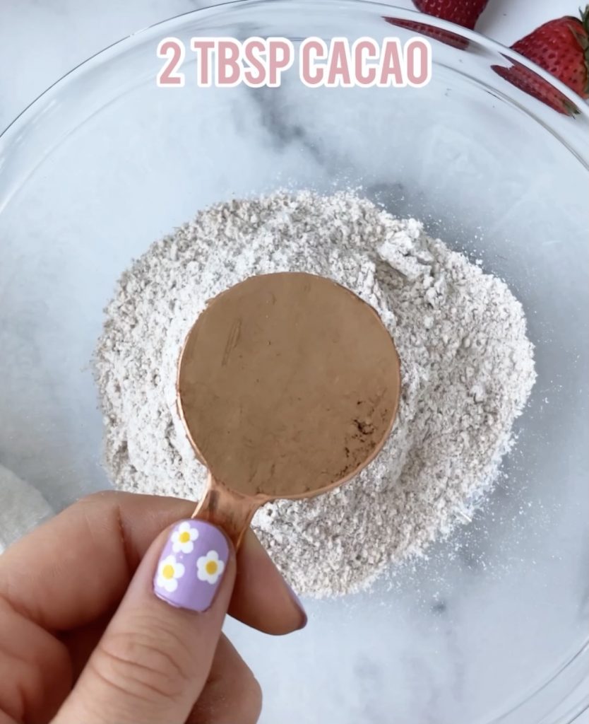cacao powder measuring cup over a bowl