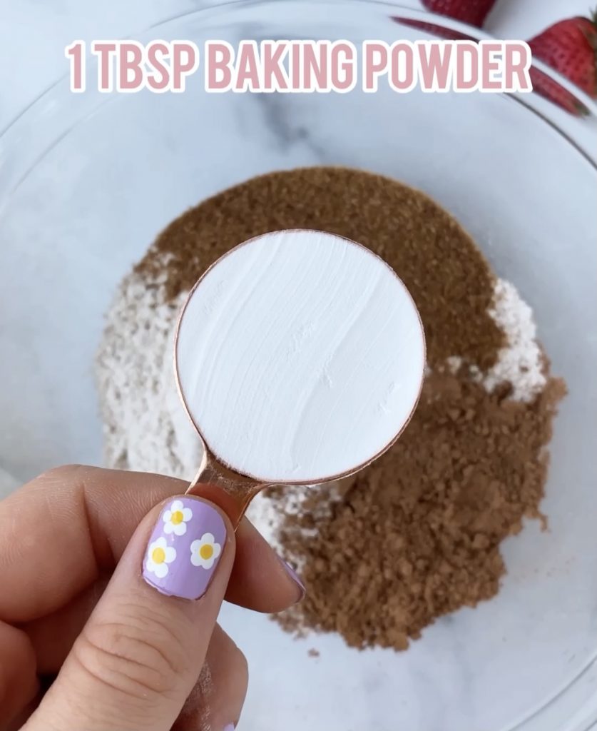 baking powder in a measuring cup over a bowl