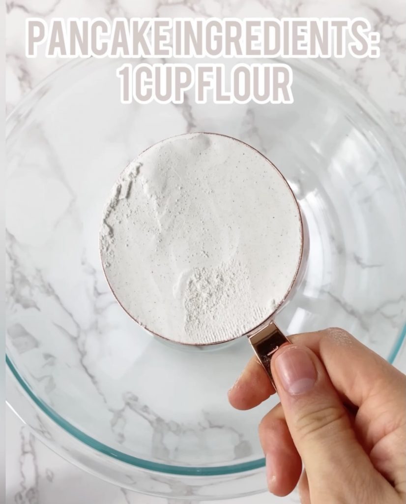 flour in a measuring cup over a bowl