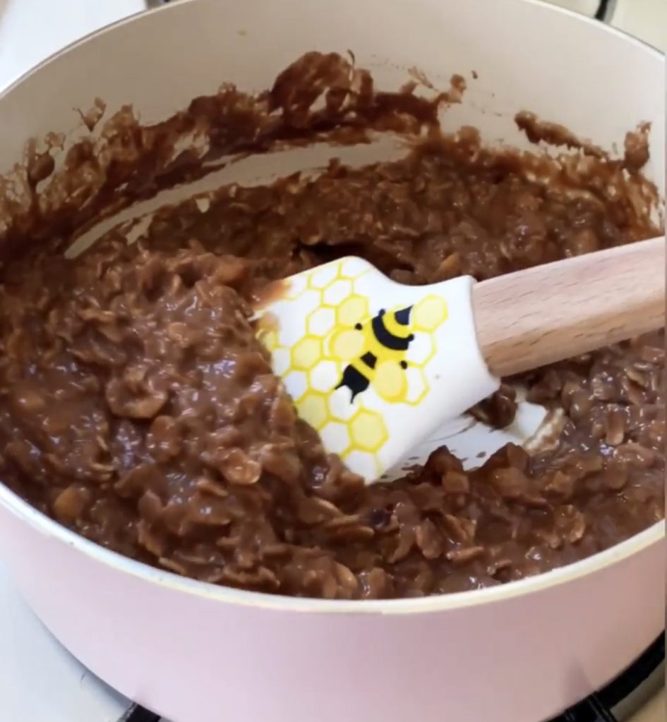 Chocolate protein oatmeal being stirred in the pot while cooking. 