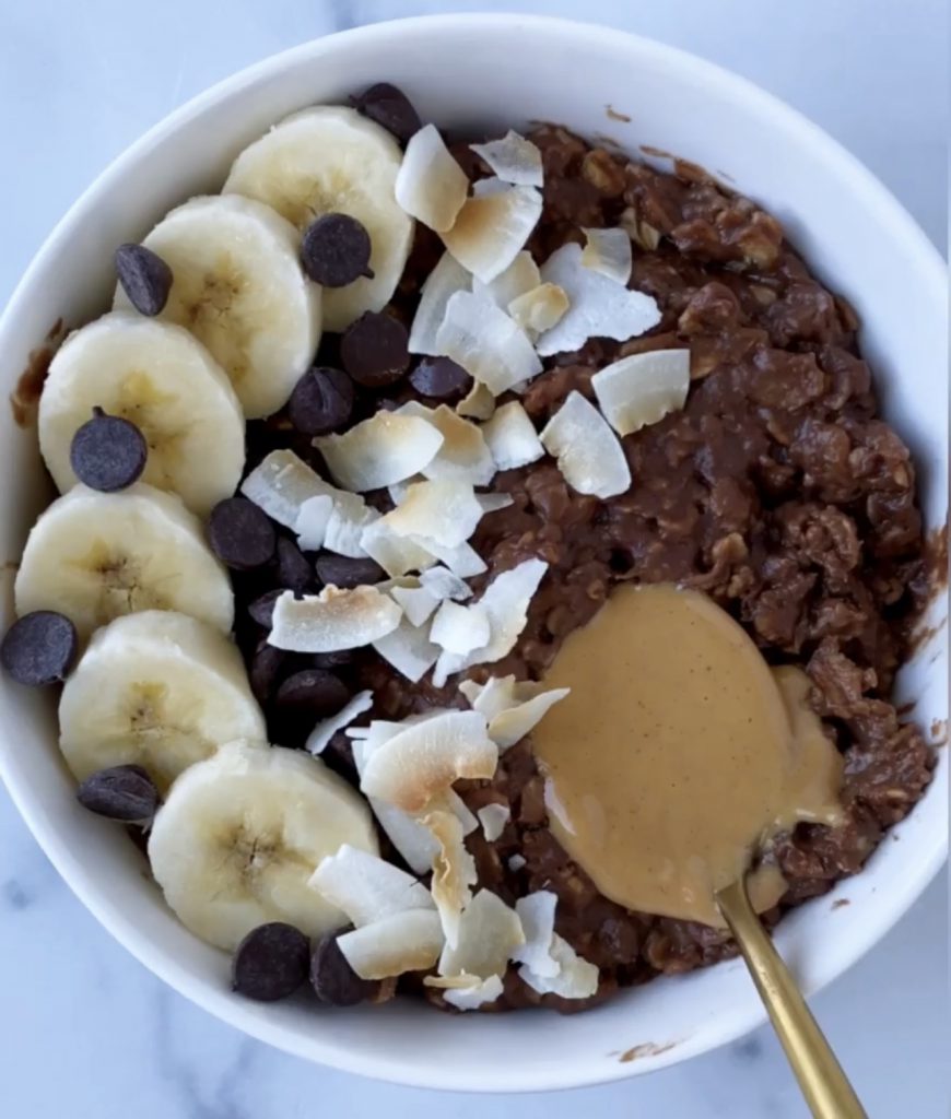 Oatmeal topped with banana, chocolate chips and coconut. 
