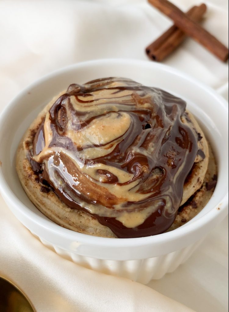 cinnamon roll covered in a chocolate and peanut butter swirl