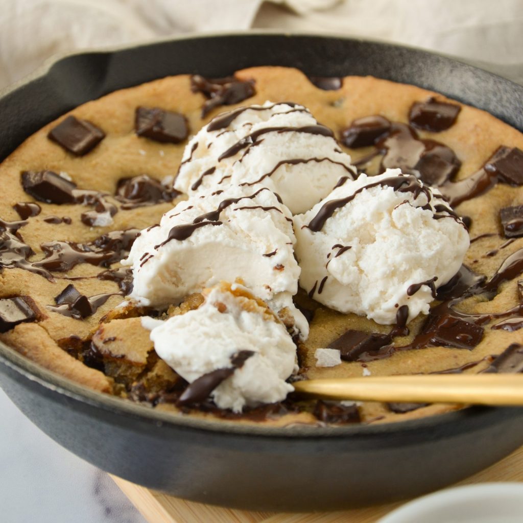 spoon digging into a chocolate chip cookie skillet