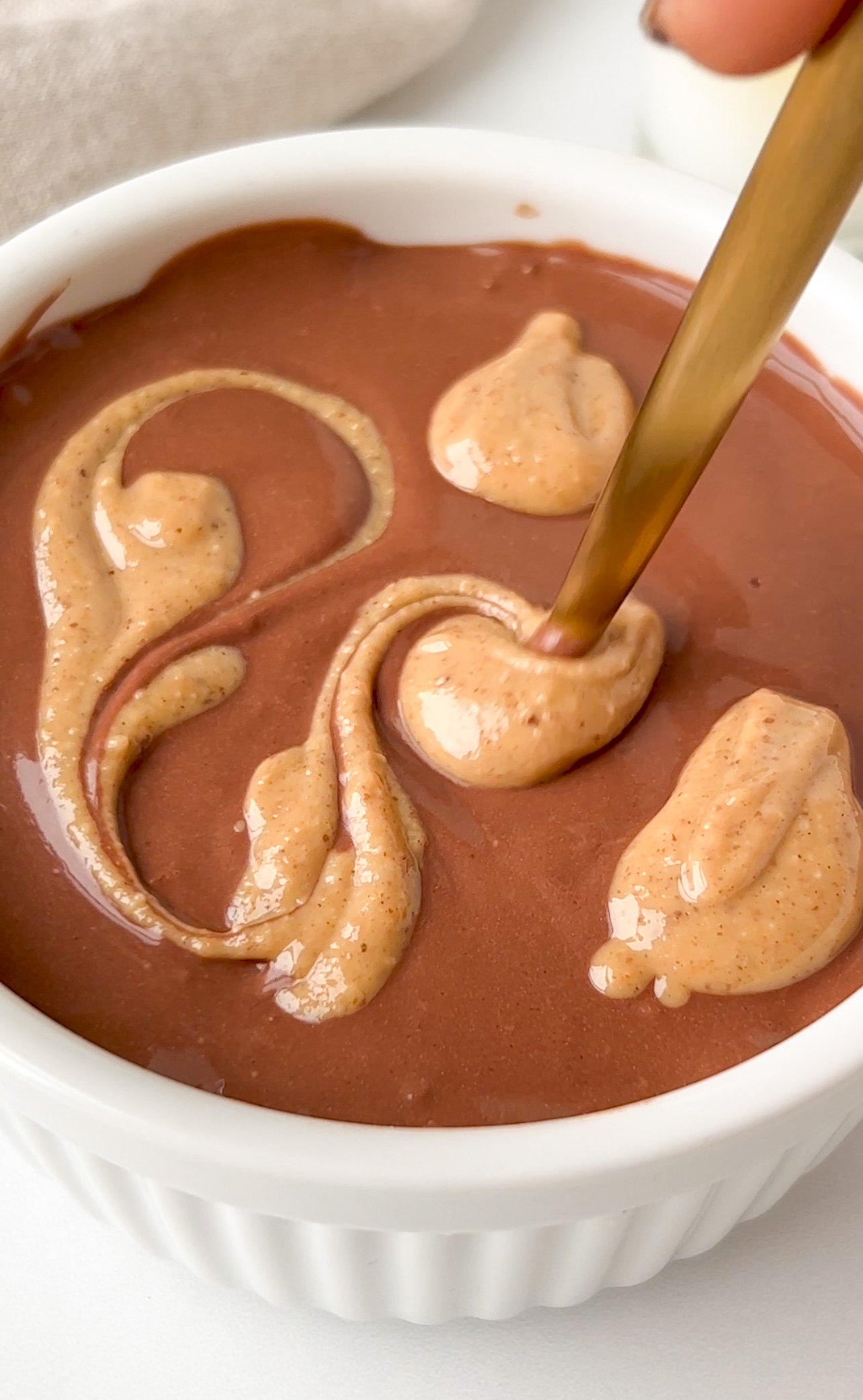spoon swirling peanut butter on chocolate 