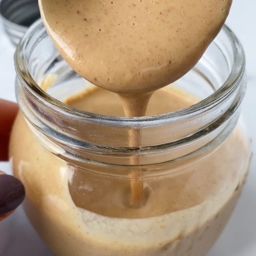 spoon in a jar of peanut sauce