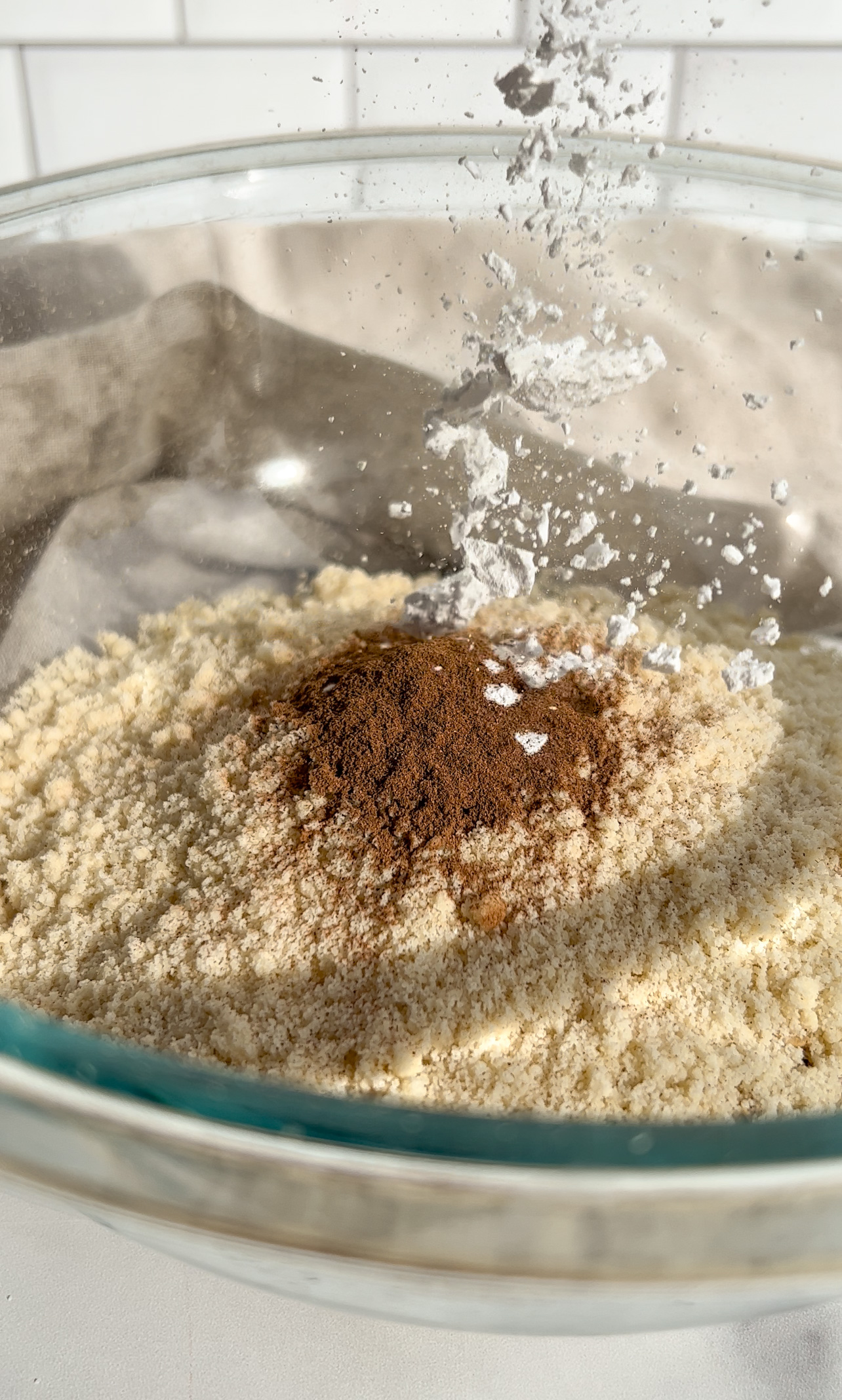 baking powder being added to a bowl of ingredients