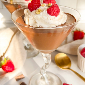 chocolate mousse in a cup with raspberries and whipped cream