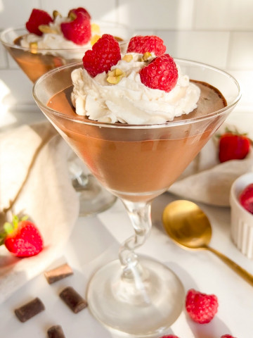 chocolate mousse in a cup with raspberries and whipped cream