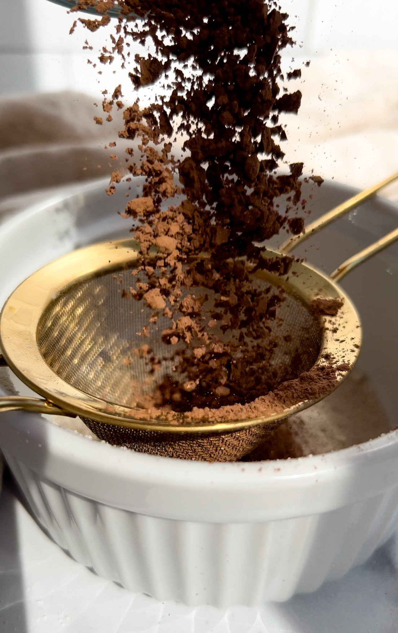 cacao powder being added to a sieve