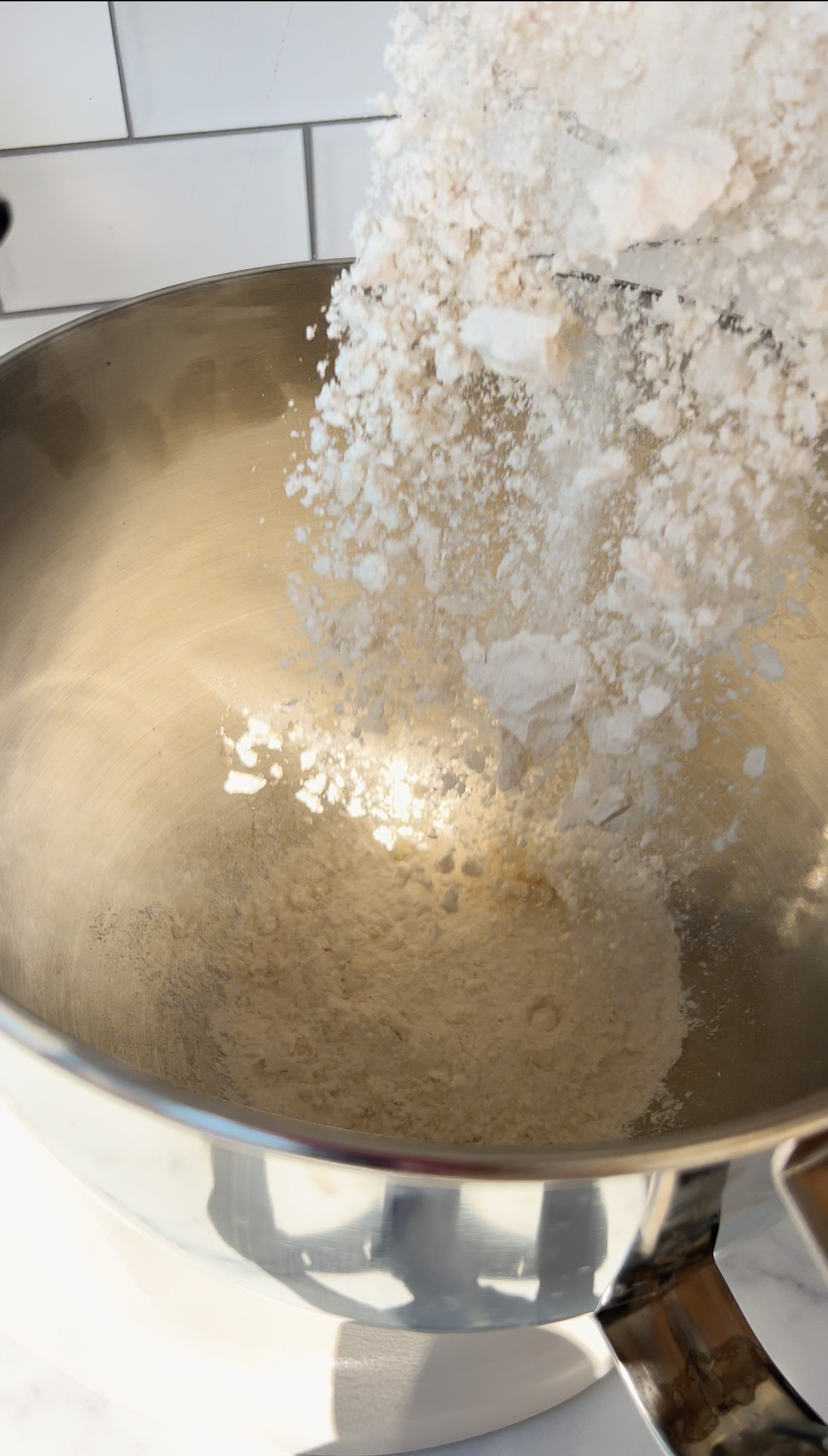 adding flour to a large bowl