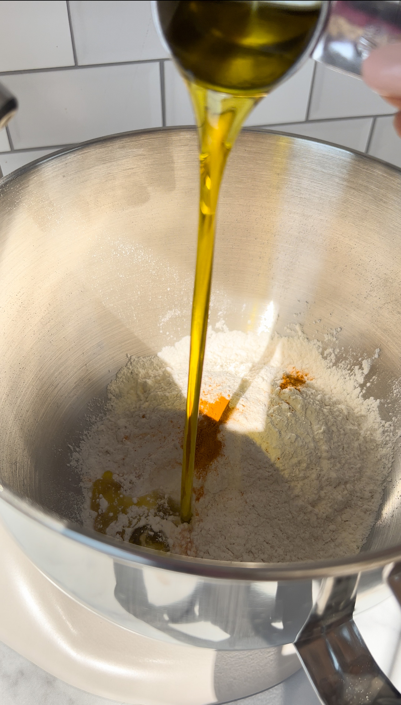 adding olive oil to a large bowl