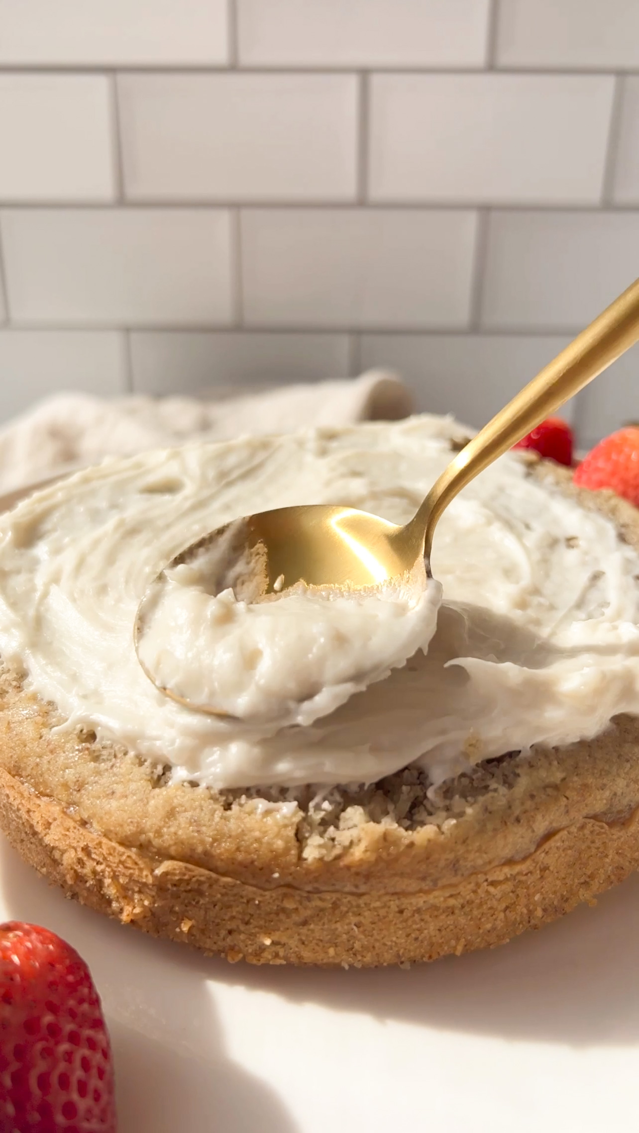 spoon spreading frosting to a cake layer