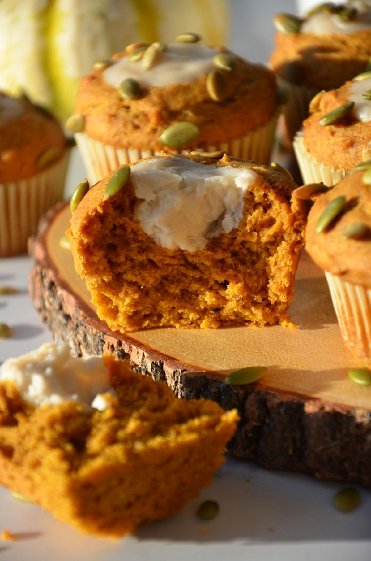 A pumpkin muffin on the table cut in half to show the filling in the middle.