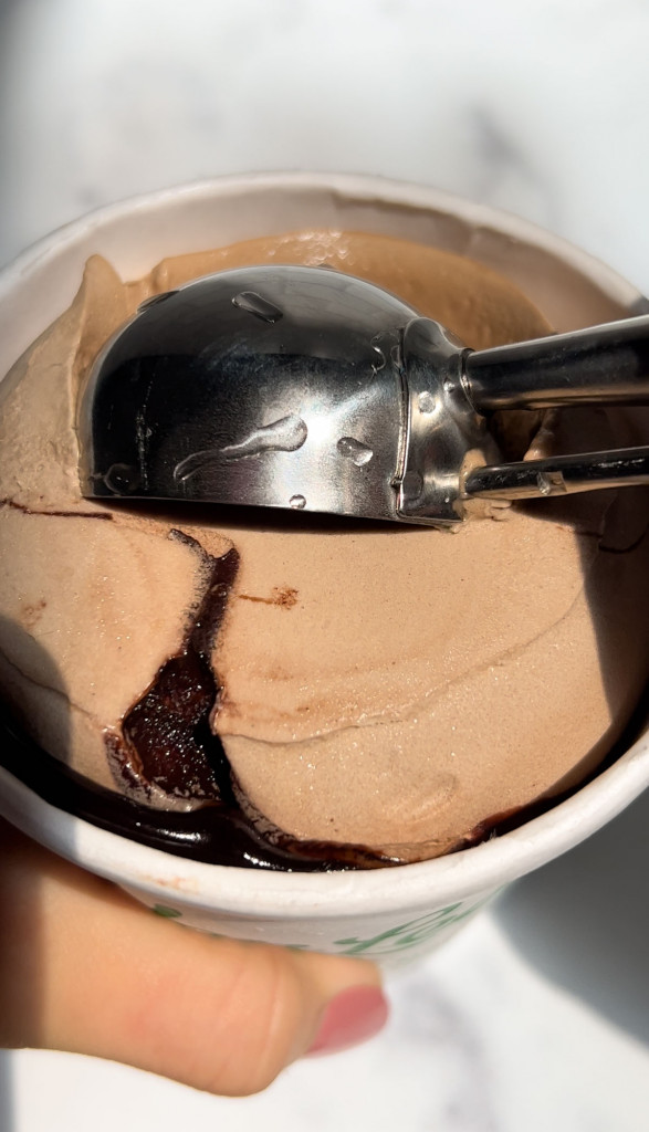 scooping chocolate ice cream from a pint