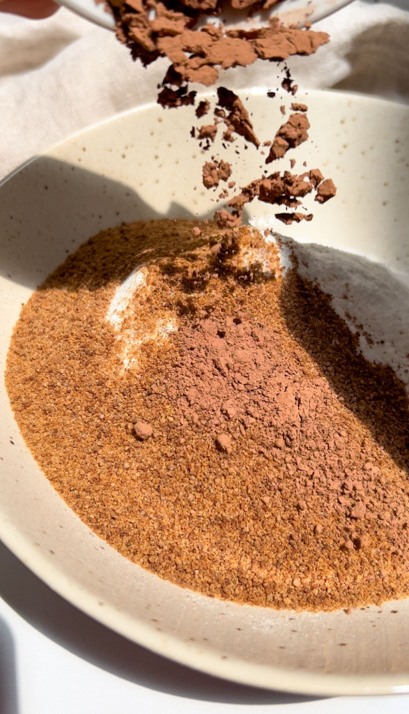cacao powder added to a bowl of ingredients