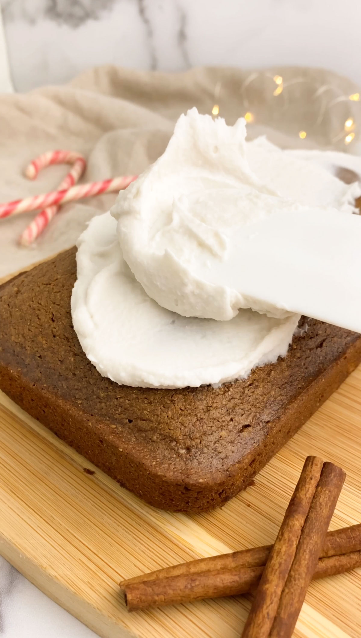 adding coconut frosting to a loaf of gingerbread