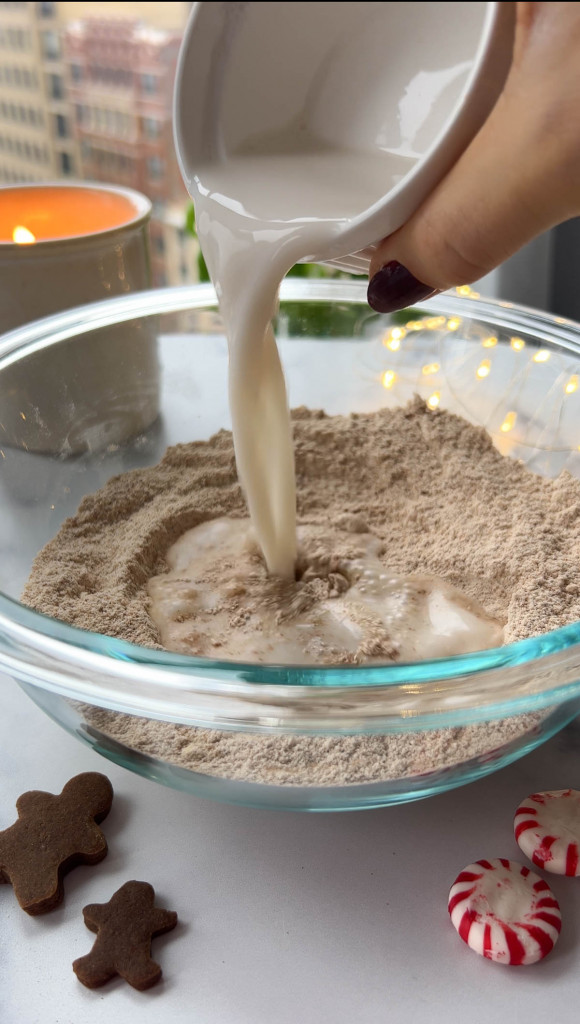 adding the wet ingredients to a bowl to make gingerbread cupcakes