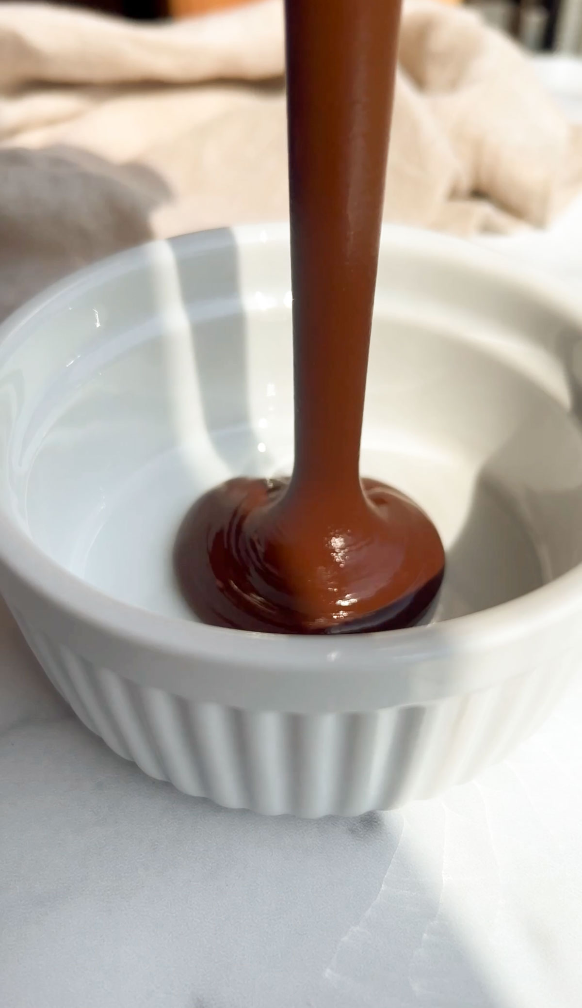 pouring melted chocolate in a ramekin