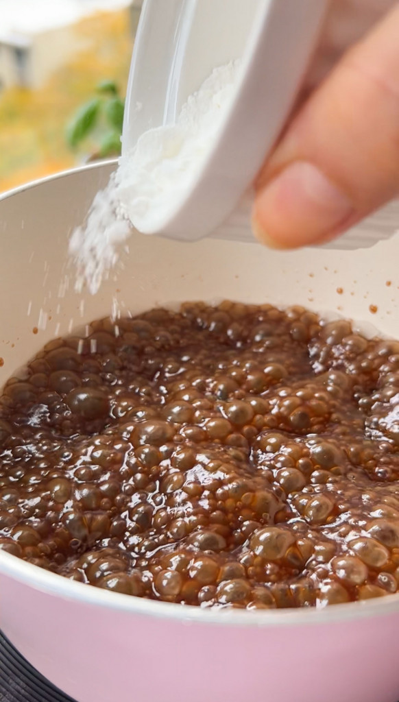 adding cornstarch in a pan over salted caramel sauce