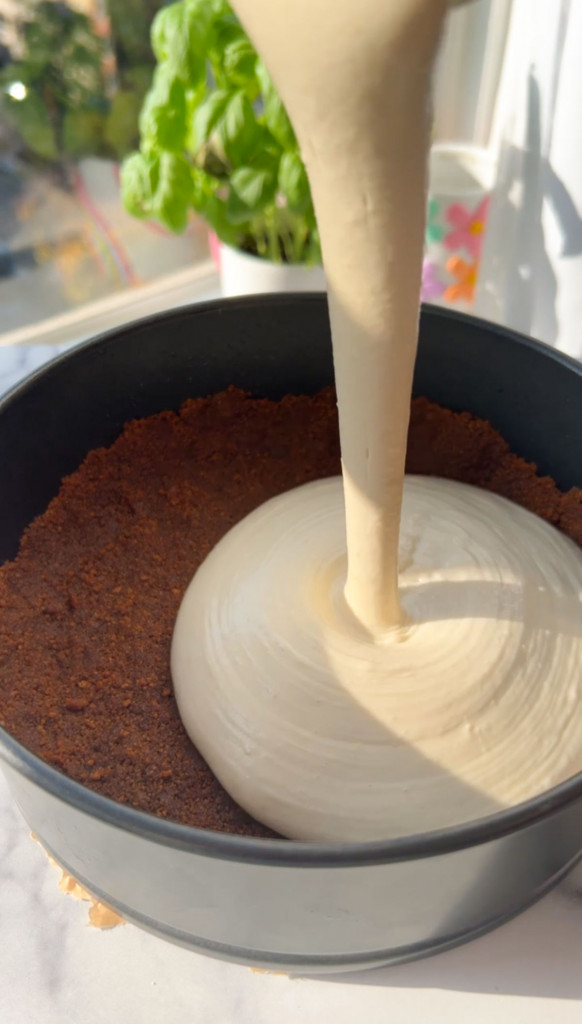 pouring the filling of a salted caramel cheesecake into a springform pan