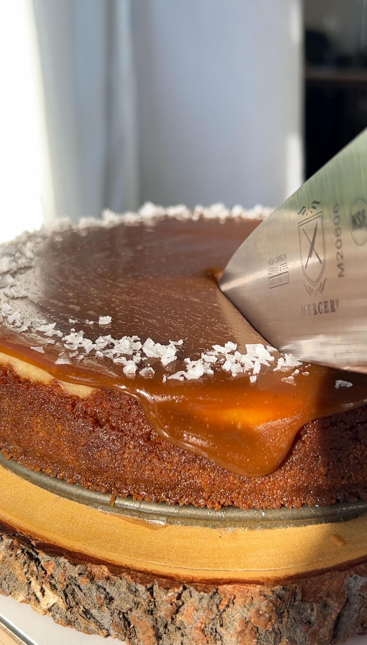 slicing into a salted caramel cheesecake