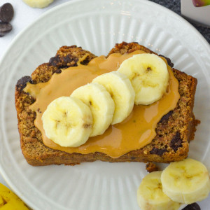 vegan banana bread slice with peanut butter and banana slices on top