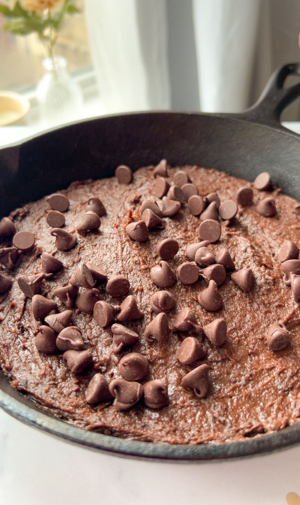 chocolate chips on top of a black bean brownie skillet