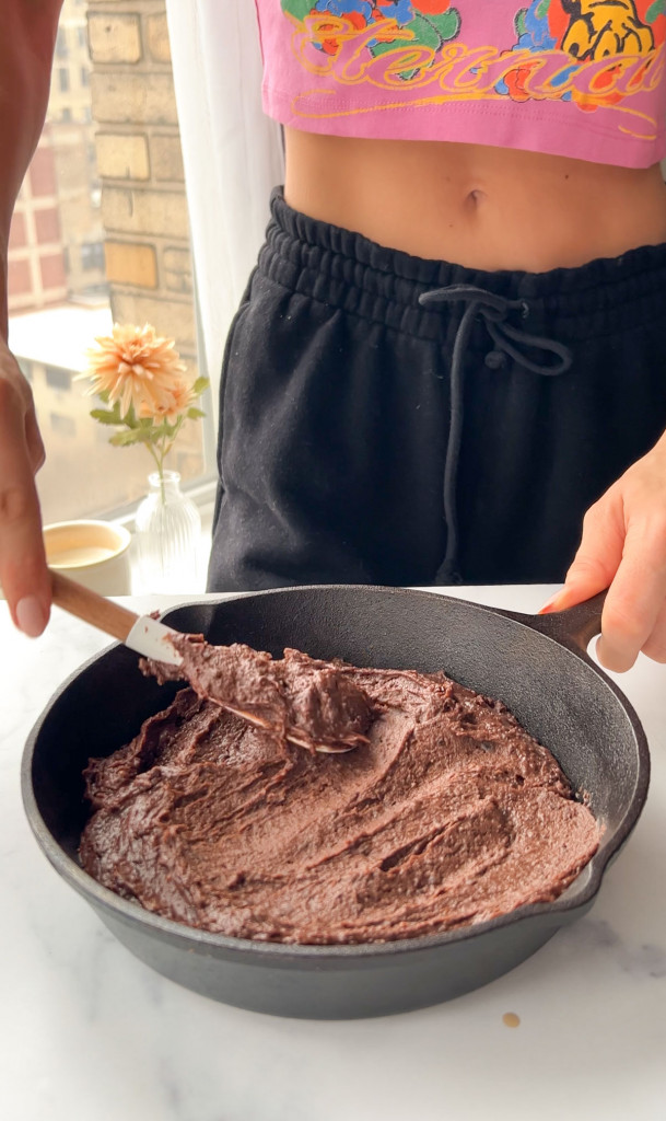 smoothing the top layer of a black bean brownie skillet