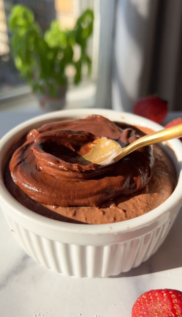 layering on a chocolate glaze on top of a bowl of blended overnight oats