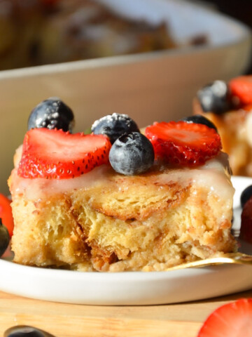 vegan french toast casserole slice on a plate topped with berries
