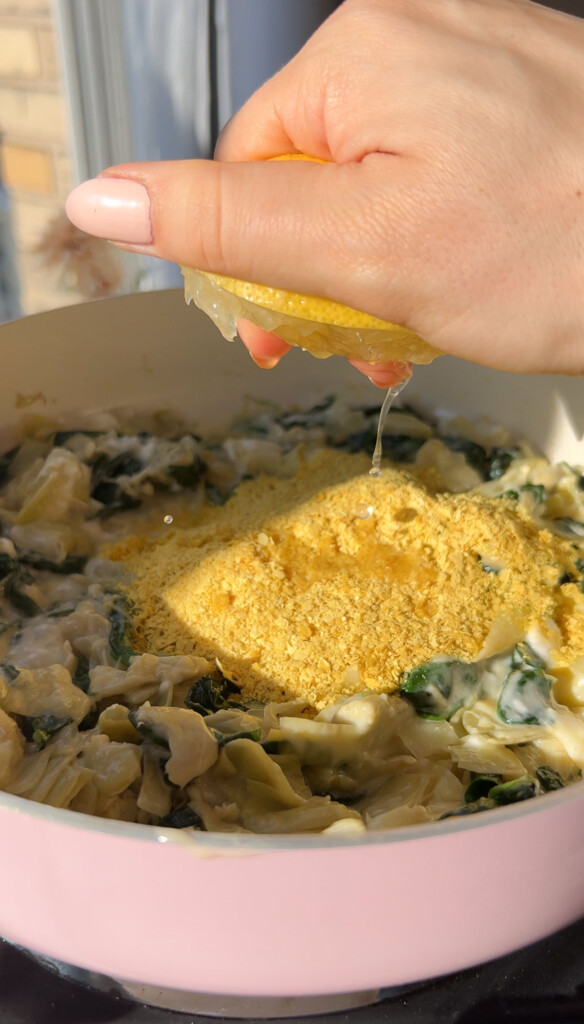 squeezing lemon juice into a pan of spinach dip
