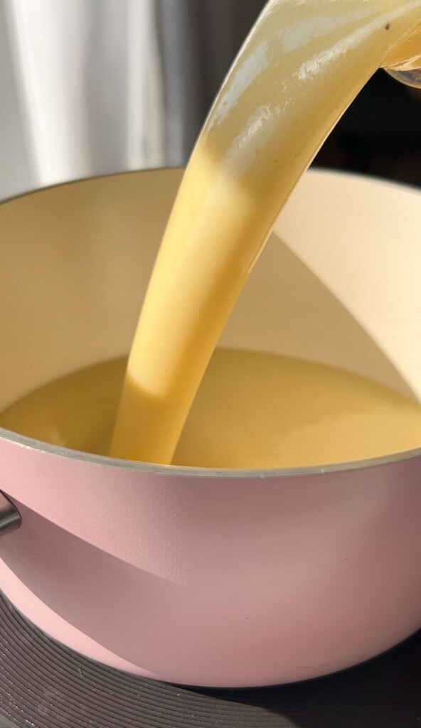 pouring lemon bar filling into a saucepan