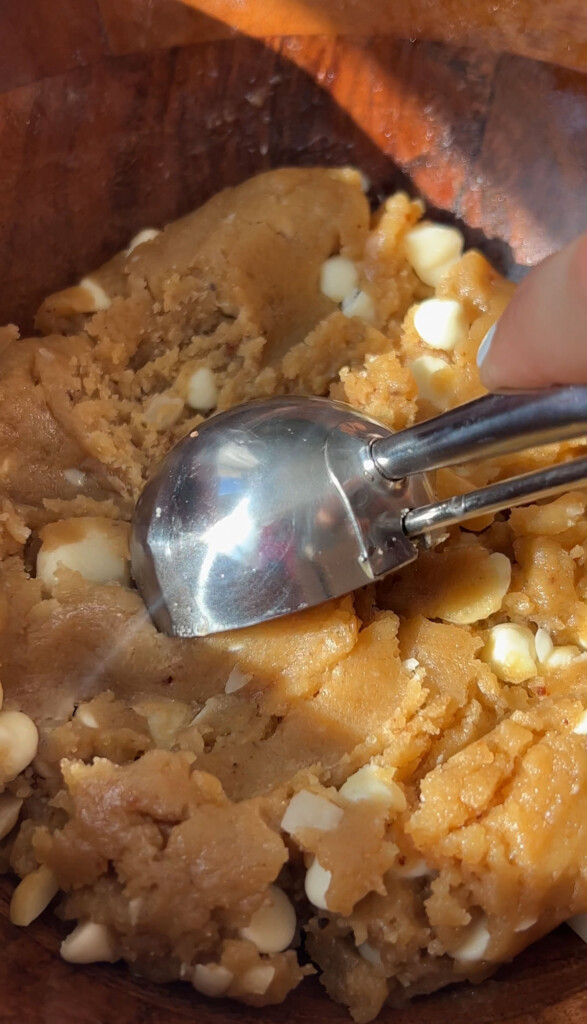 cookie scoop scooping up white chocolate macadamia cookie dough