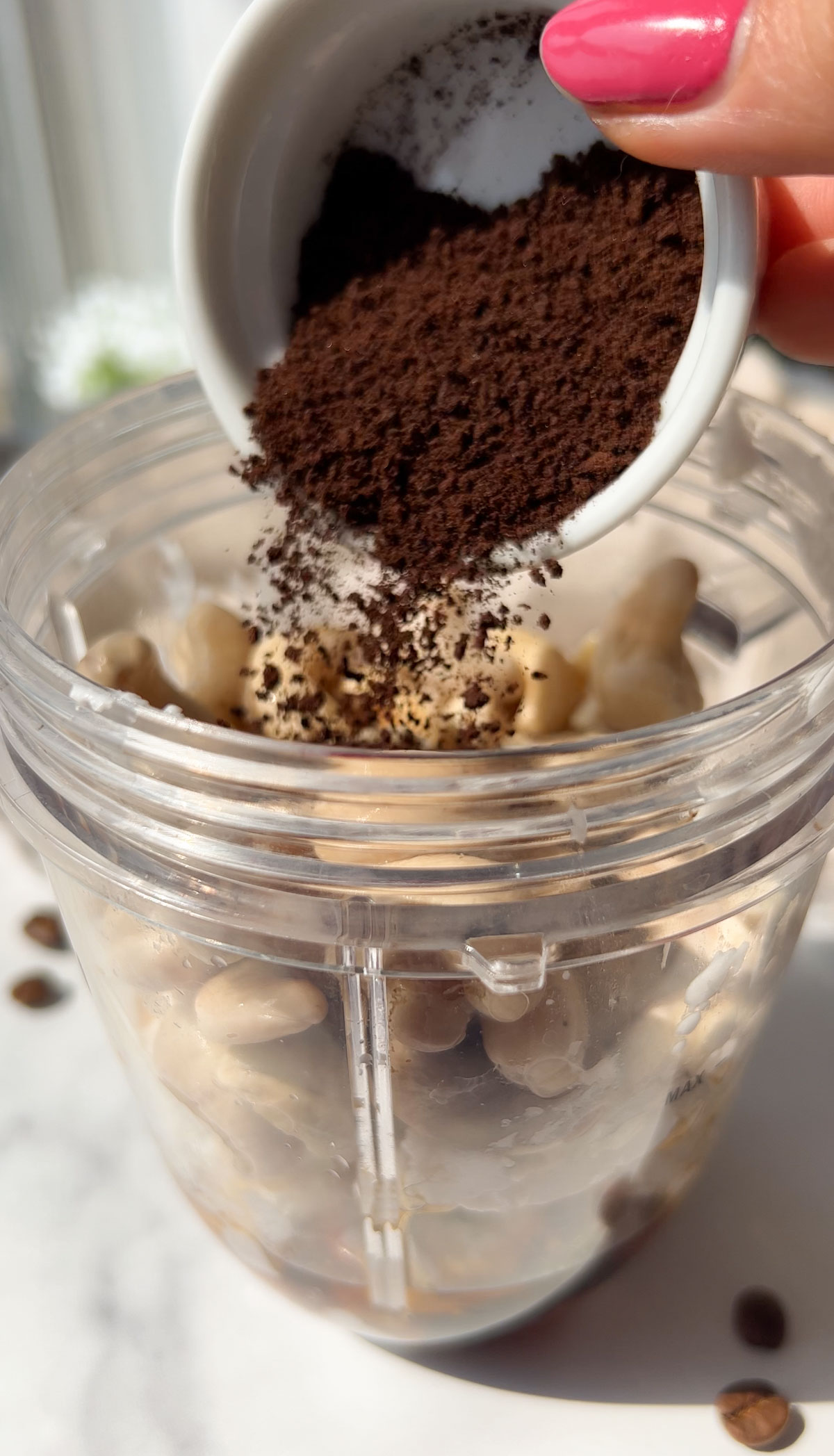 Adding all the ingredients to make vegan coffee ice cream to a blender.