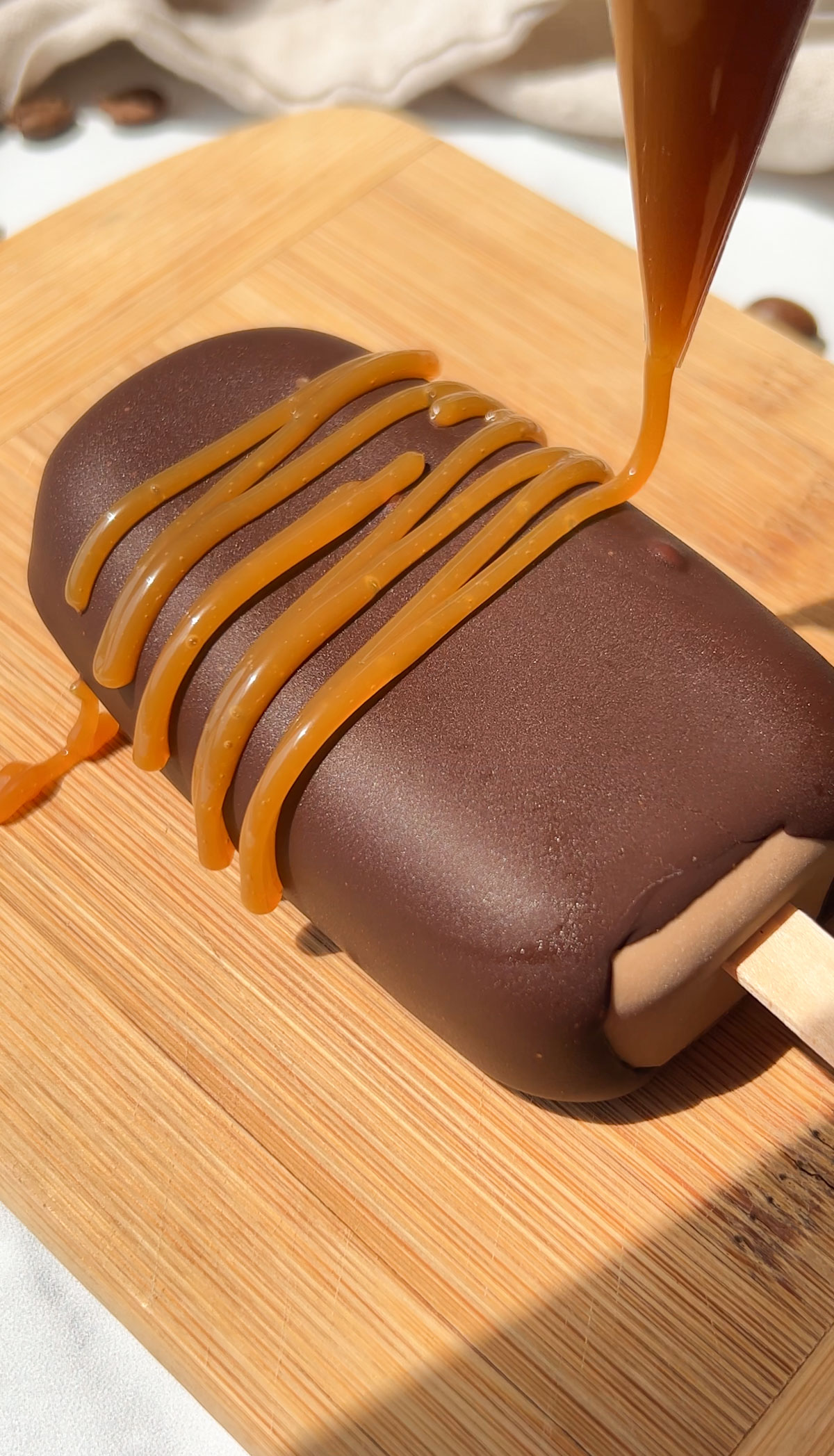 Drizzling the vegan coffee ice cream bars with caramel.
