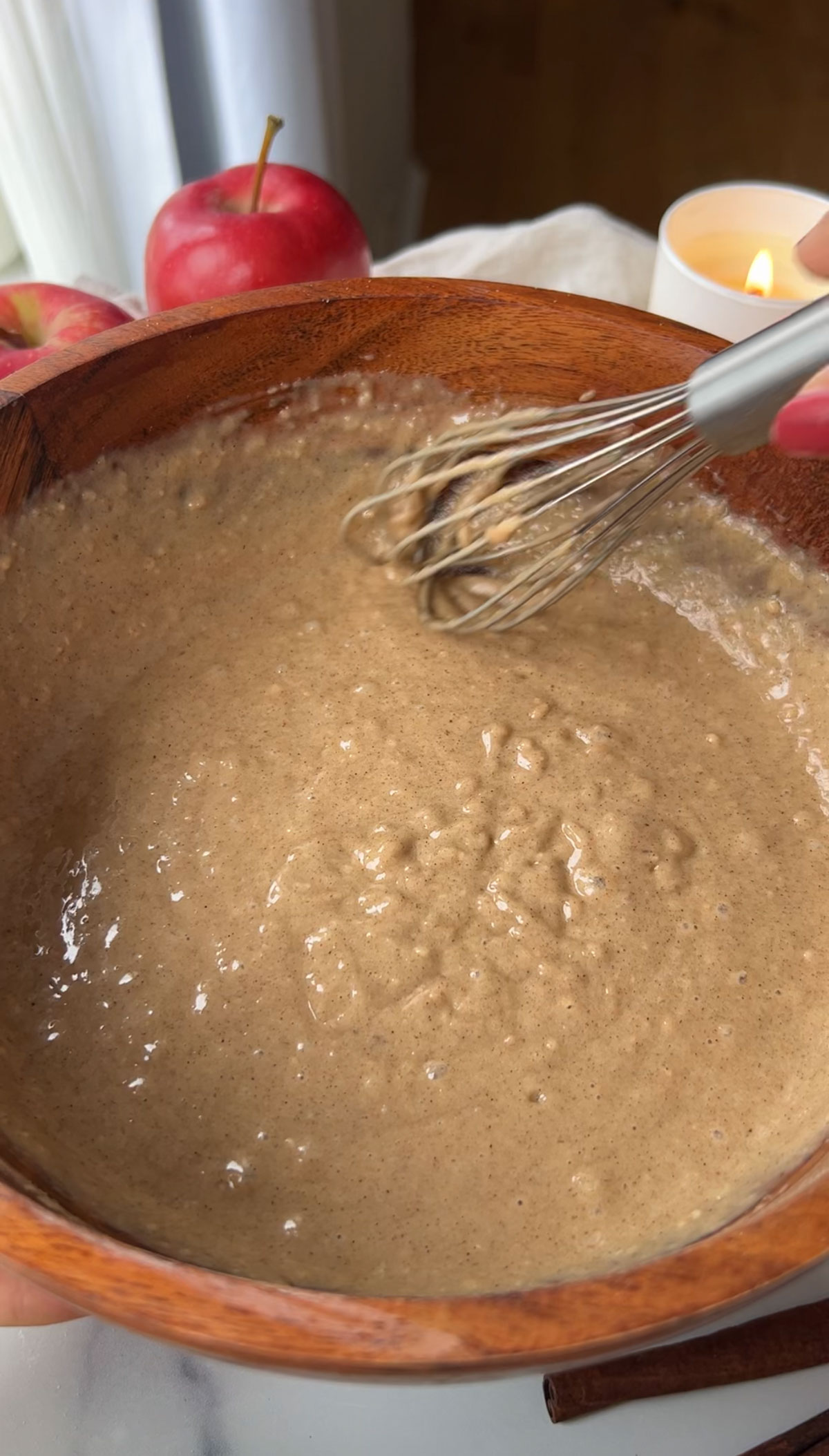 Apple cake batter in a mixing bowl mixing with a whisk.