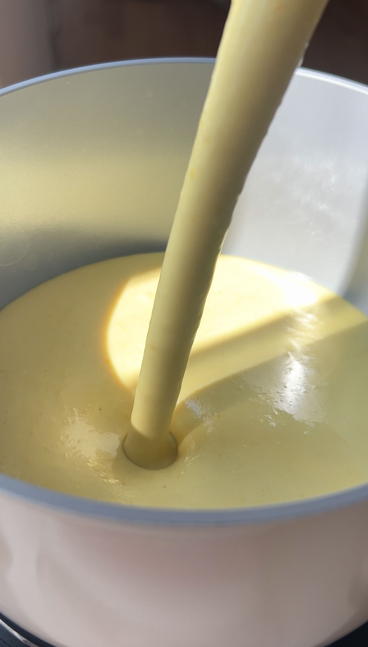 Pouring the lemon pie mixture into a pan to heat.