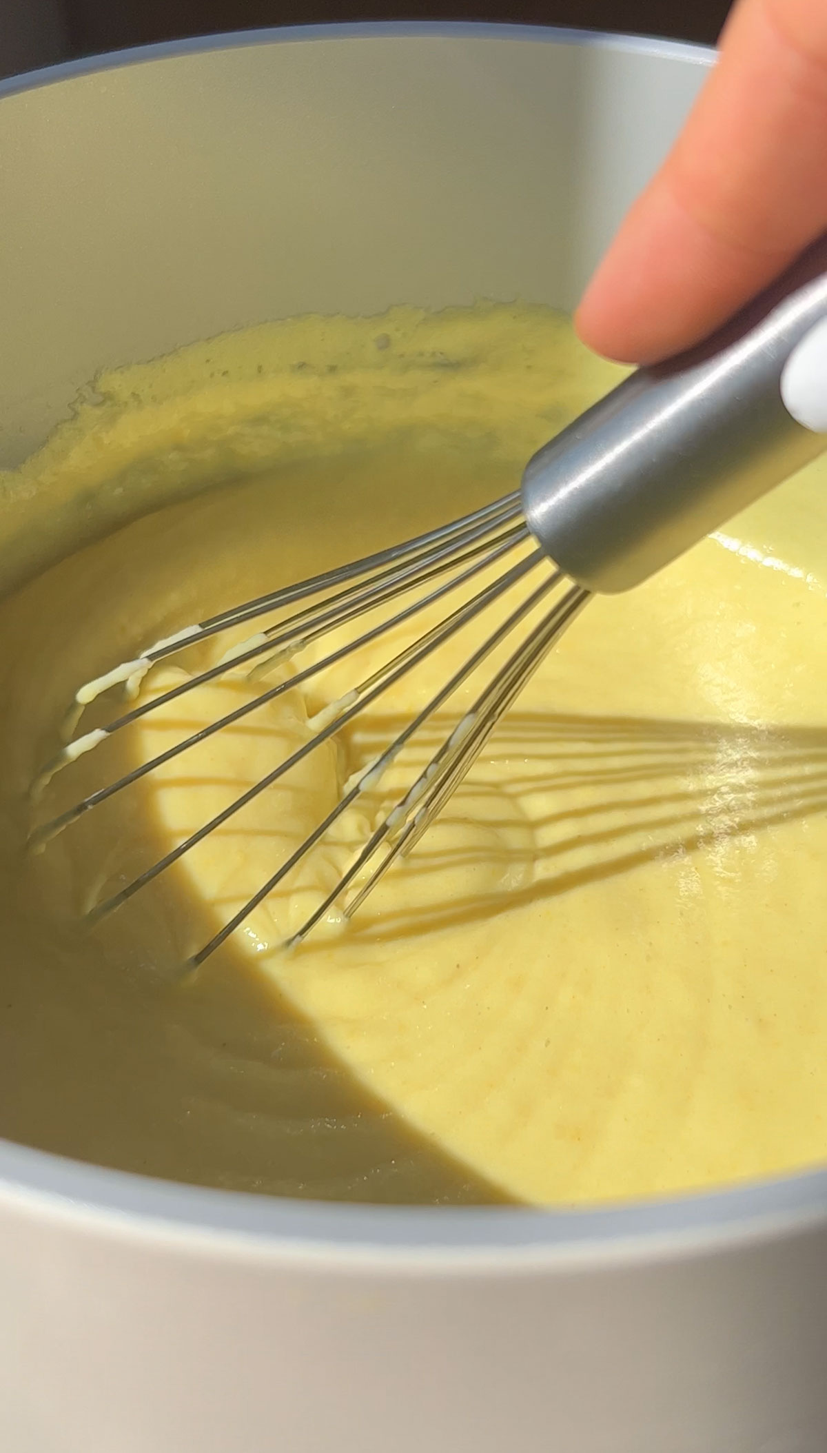 Whisking the vegan lemon pie filling in a saucepan.