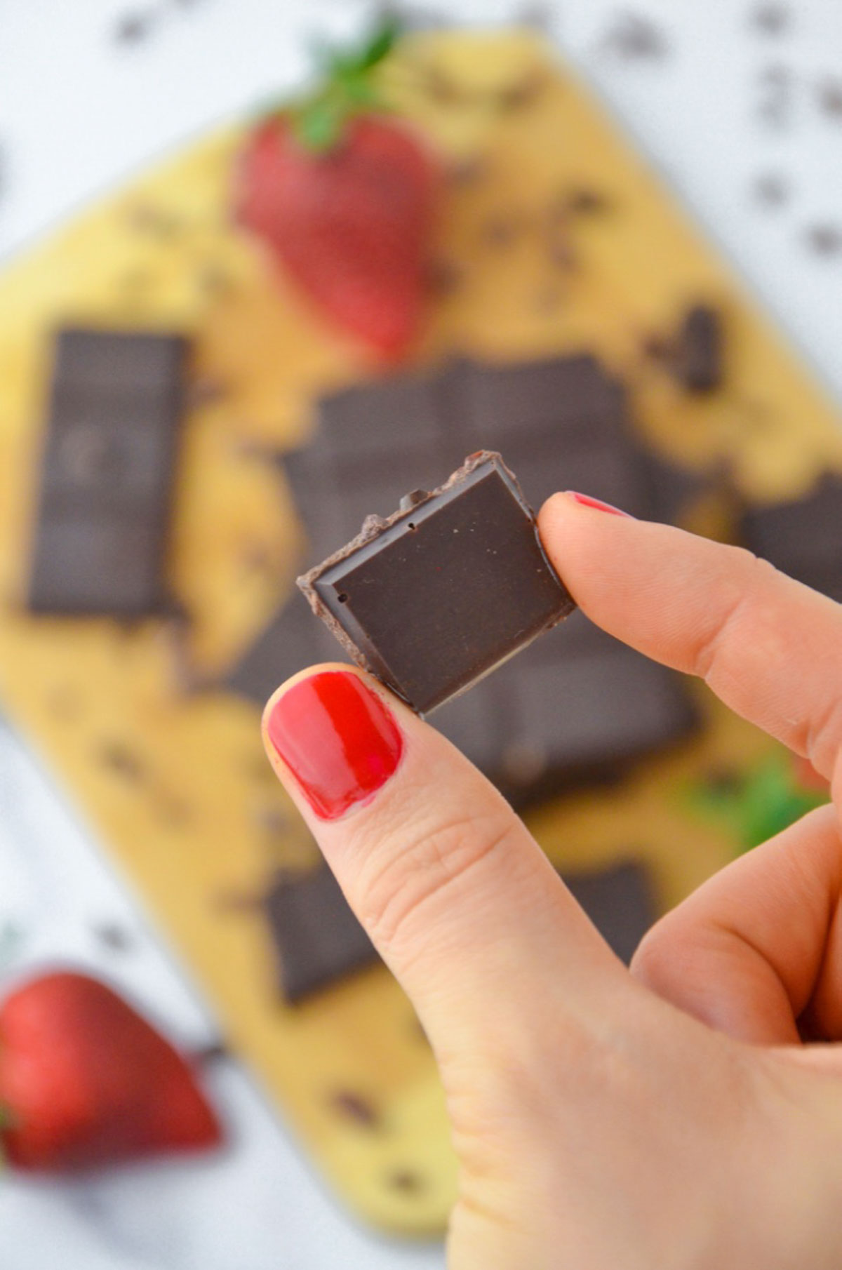A hand holding up a piece of homemade chocolate.