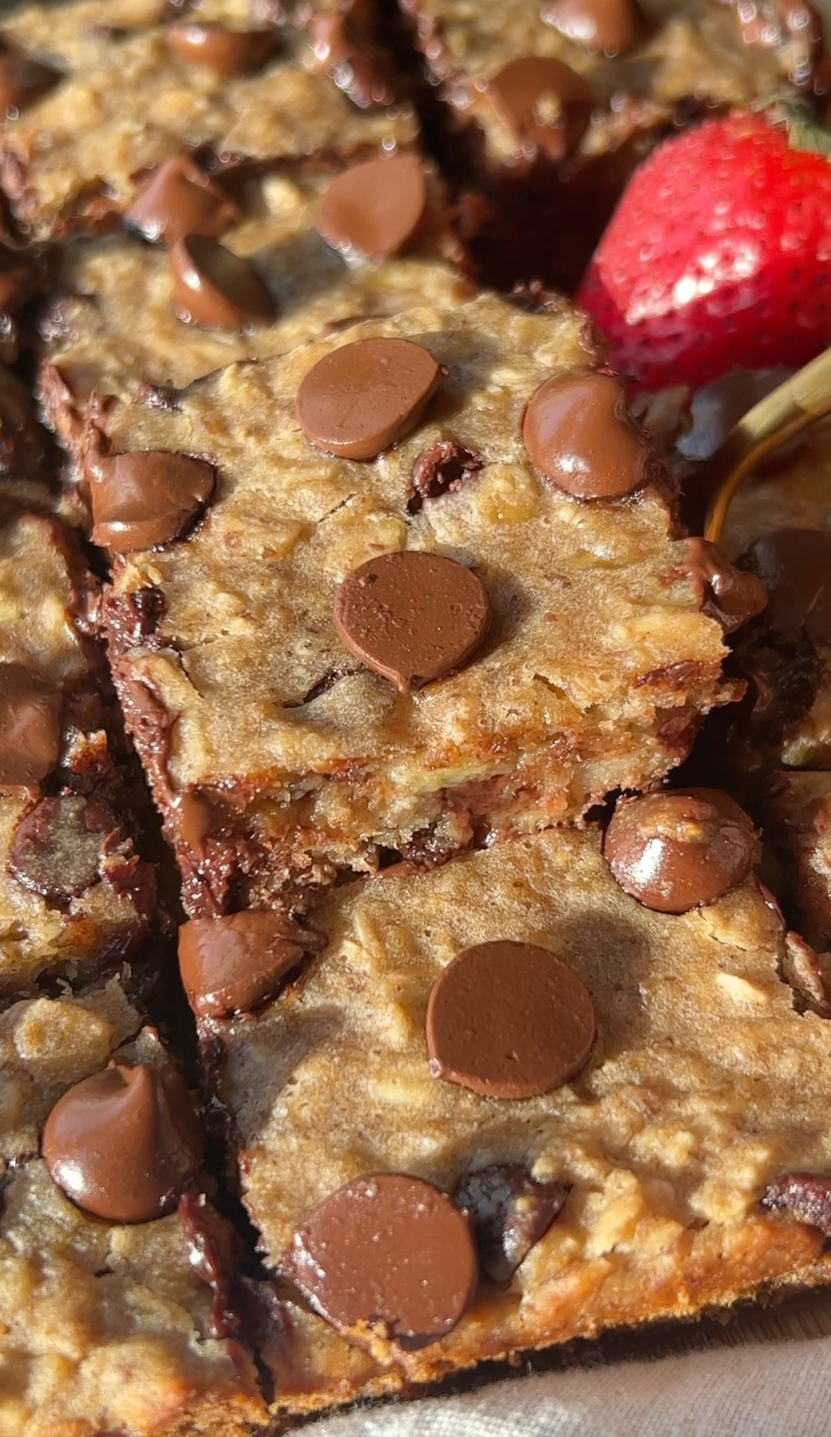 Vegan baked oats squares with chocolate chips piled on top of each other.