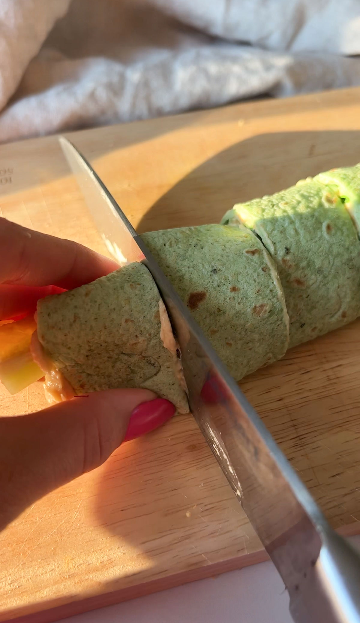 Slicing the tortilla pinwheels into bite sized pieces.