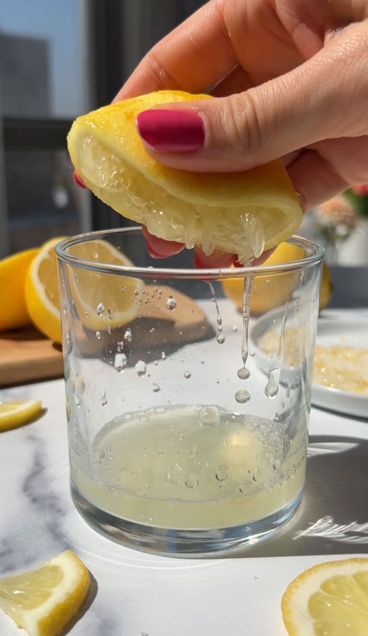 Squeezing lemon juice into a glass.