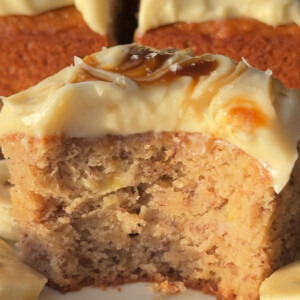 Frosted vegan banana cake portion with a bite missing.