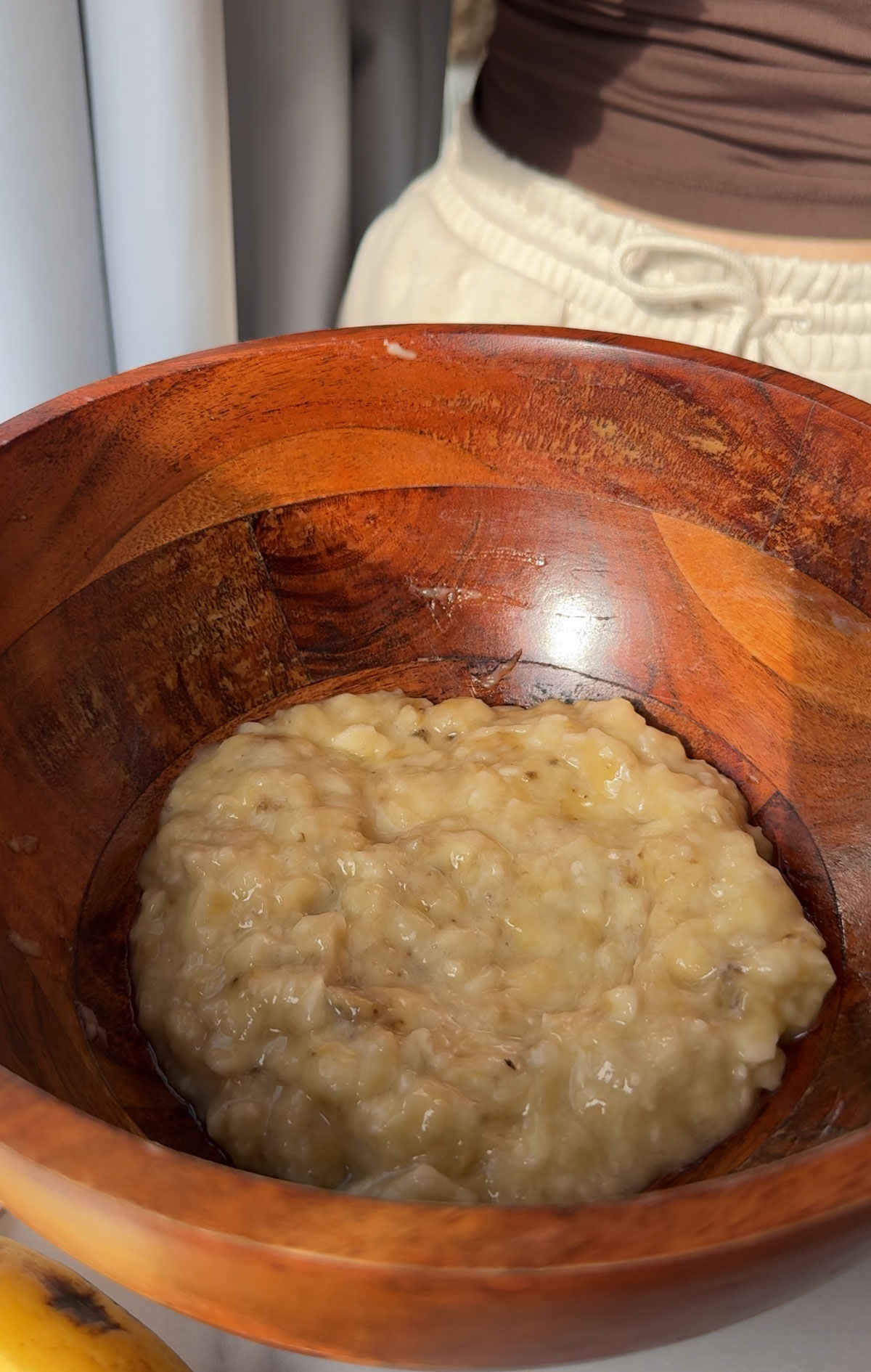 Mashed banana in a brown wooden bowl