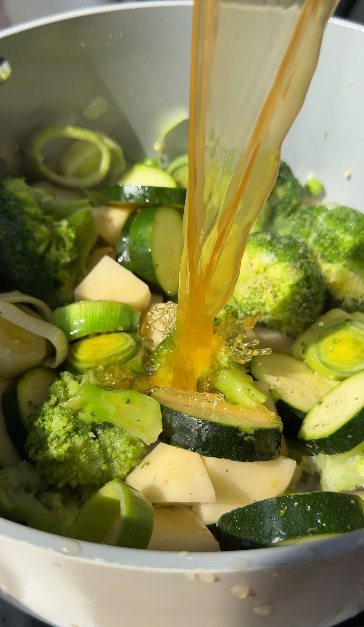 Broth being added to the vegetables for this soup.