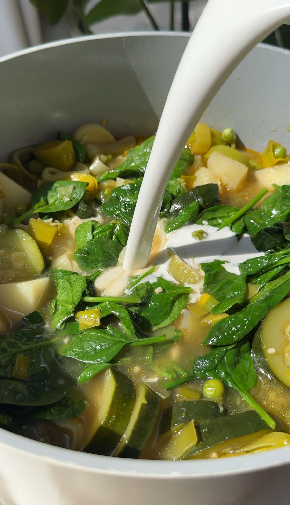 Cream being added to the vegetables for the green soup.