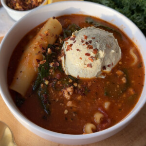 A bowl of vegan lasagna soup topped with tofu ricotta.